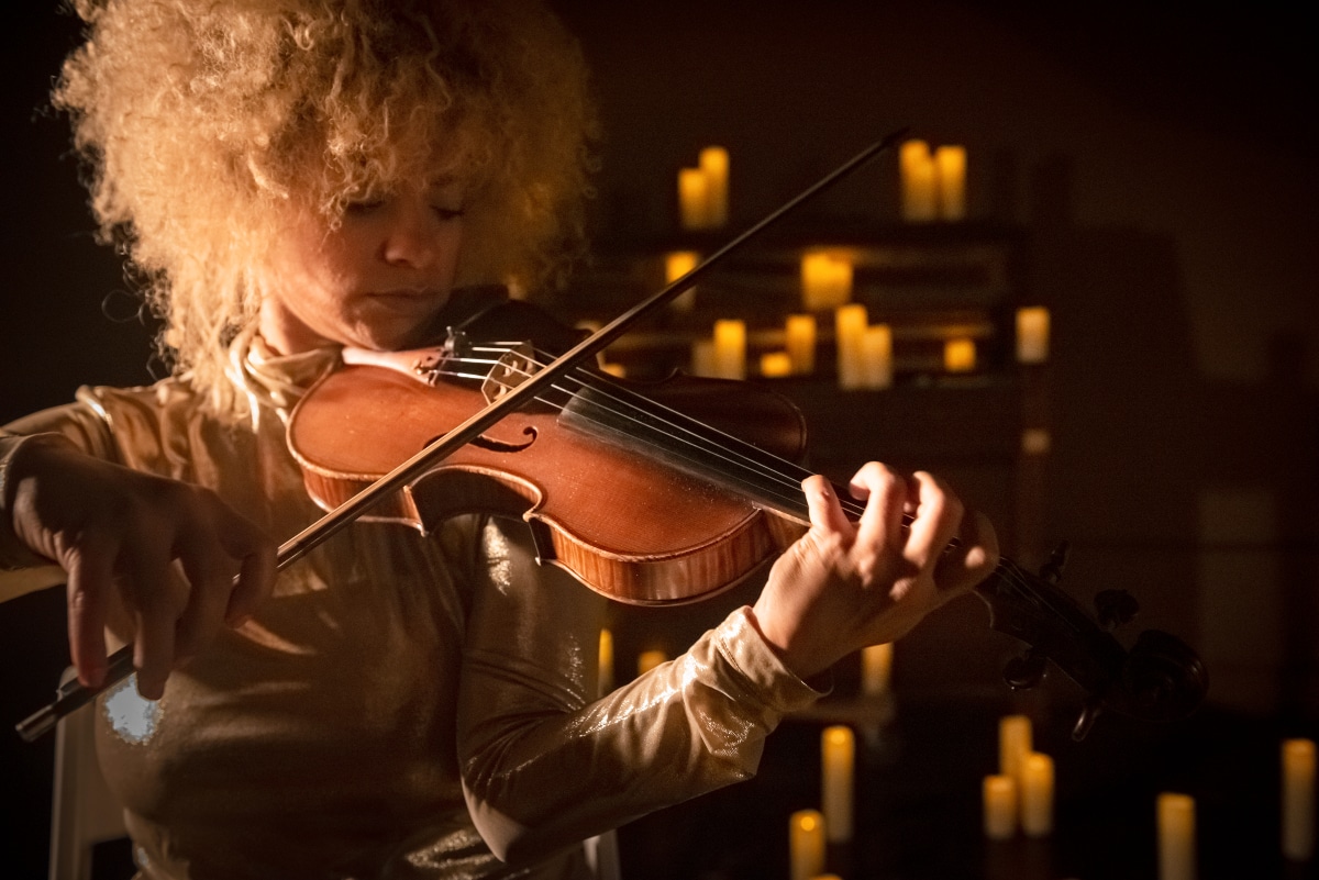 Musician playing violin by candlelight